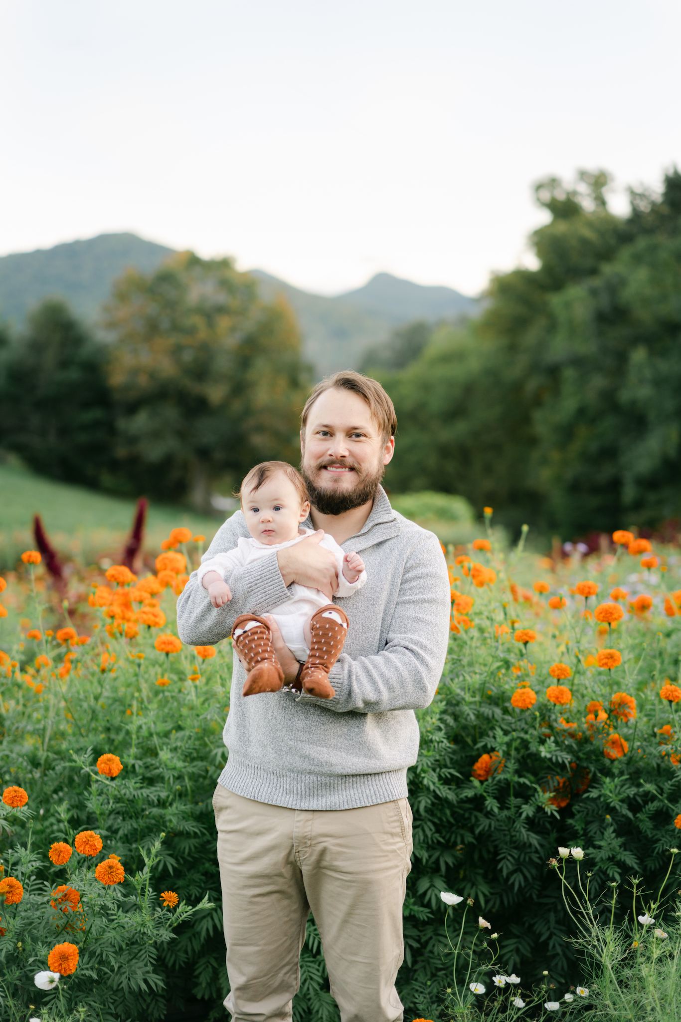 Dad holding baby with mountains in the background by Asheville family photographer, Lauren Sosler Photography.