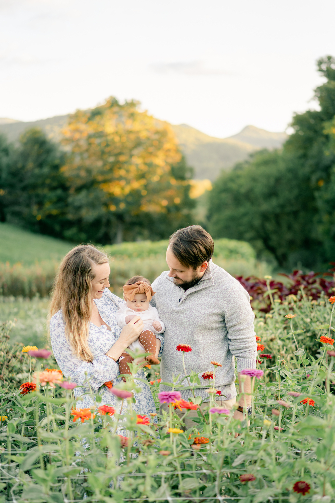 Candid image of Mom, Dad and baby at flower farm. Photo by Lauren Sosler Photography.
