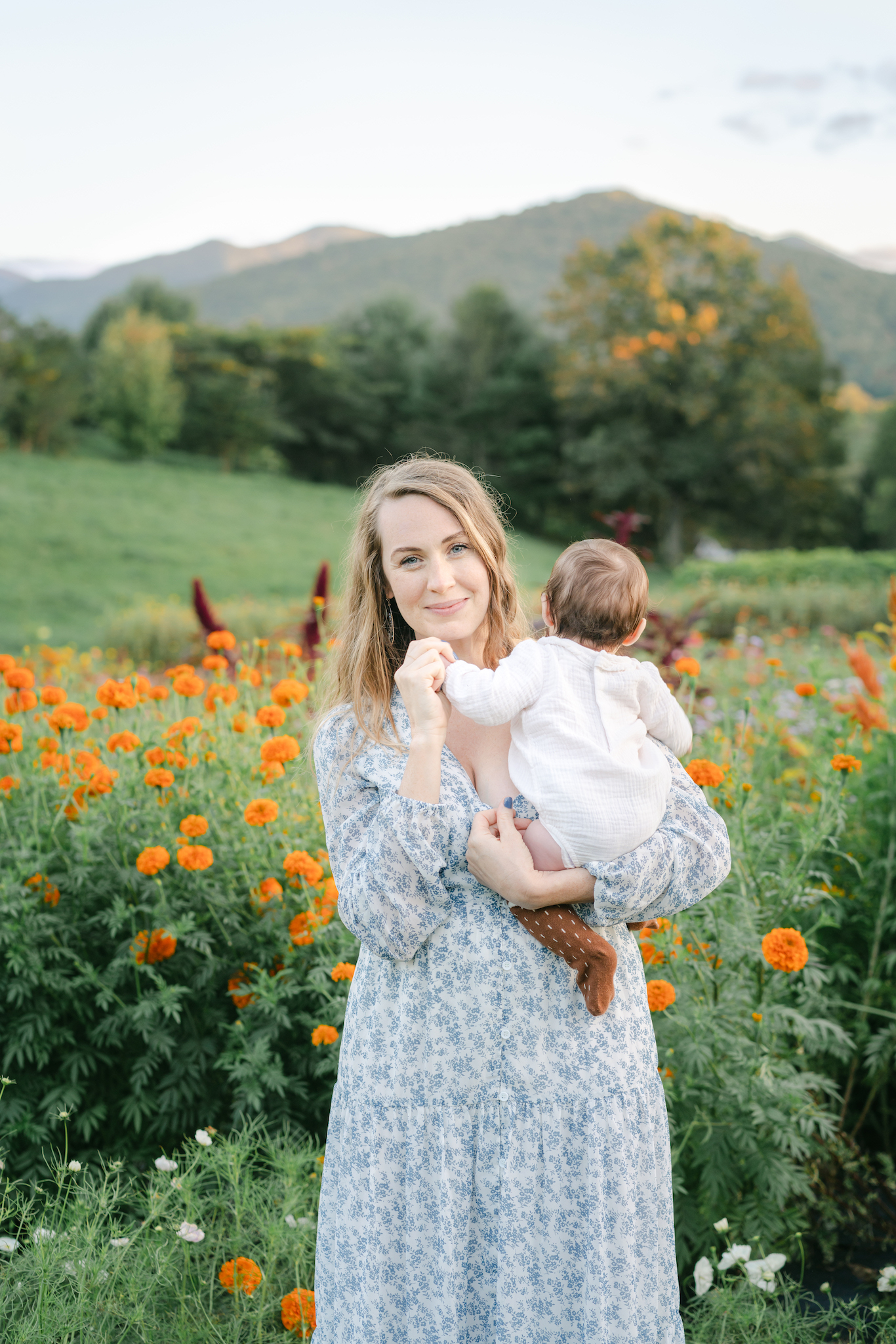 Photo of Mom holding baby with mountains and flowers in the background by Lauren Sosler Photography.