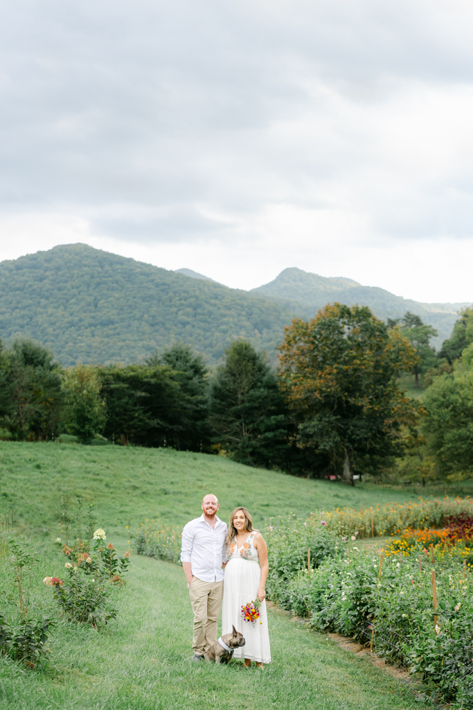 Couple with dog during their flower farm maternity session near Black Mountain. Photo by Asheville maternity photographer, Lauren Sosler Photography.