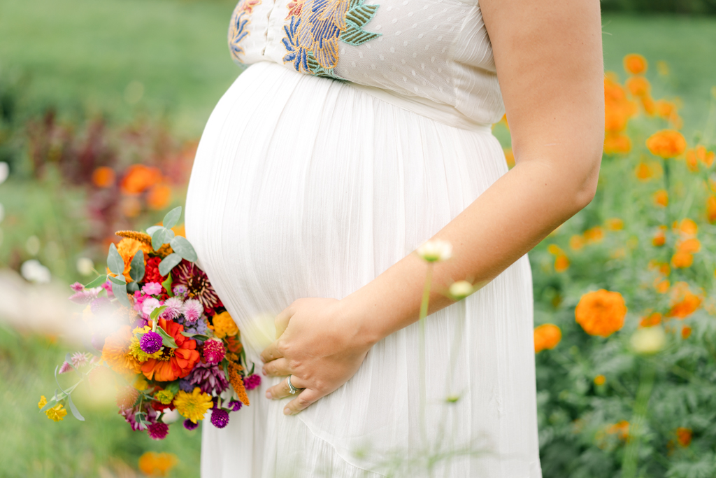Closeup of bump and flowers during maternity session in Asheville, NC. Photo by Lauren Sosler Photography.