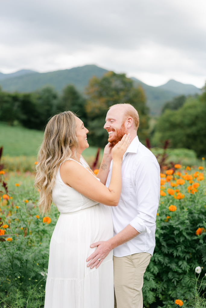 Candid photo of couple during maternity session at the Never Ending Flower Farm outside of Asheville, NC. Photo by Lauren Sosler Photography.