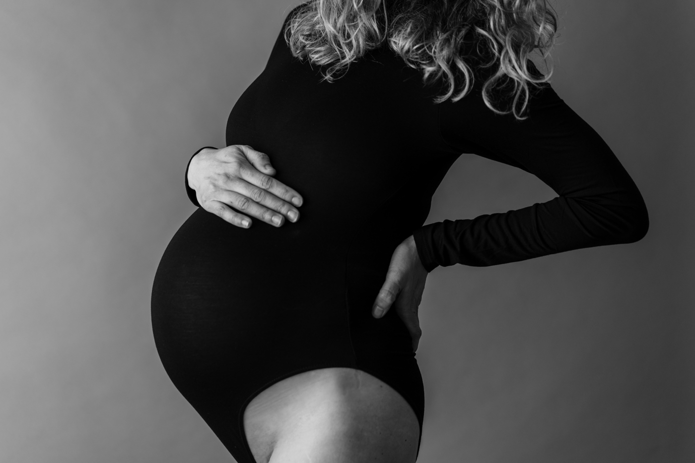 Black and white closeup of bump during dancing-inspired studio Maternity Session. Photo by Lauren Sosler Photography.