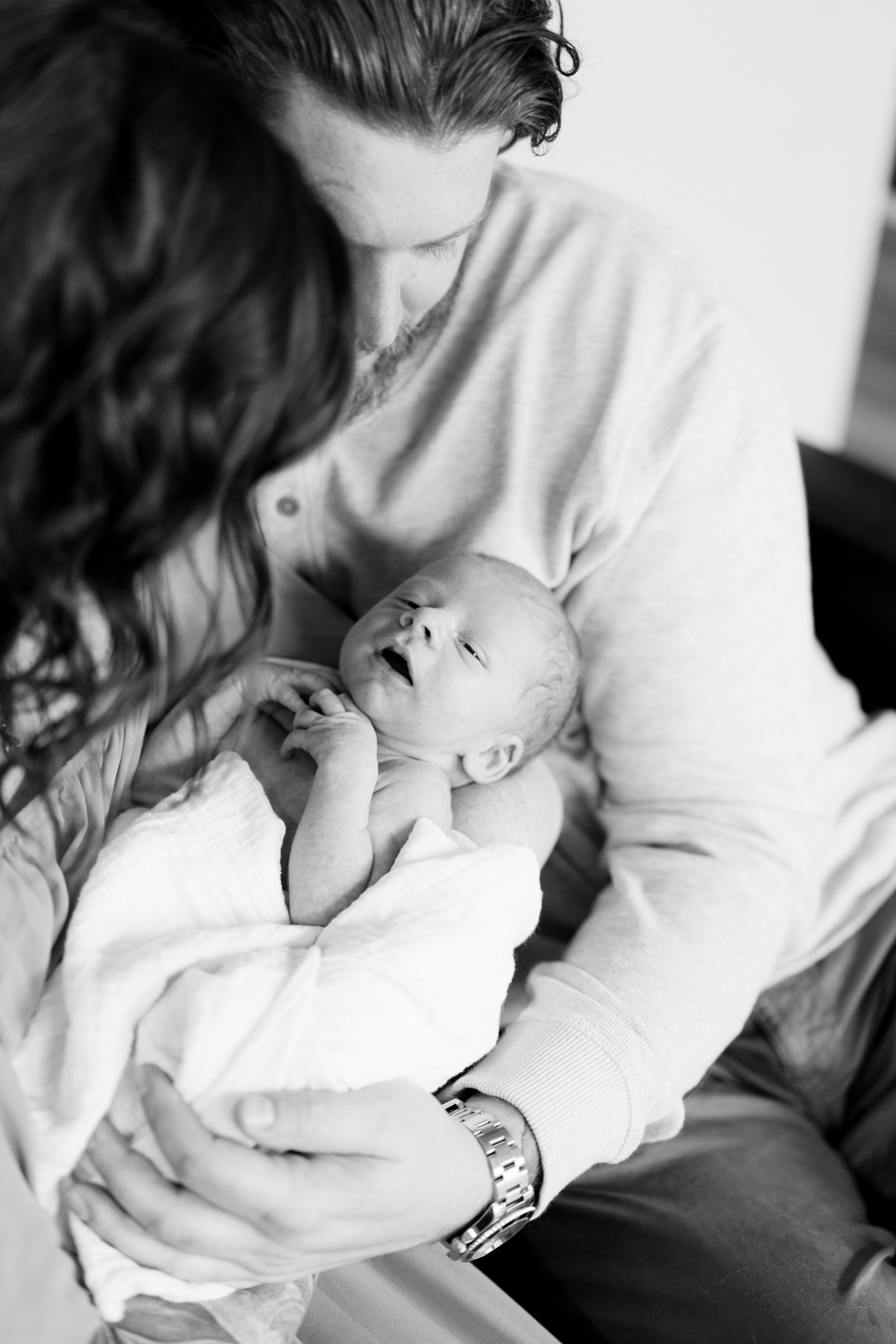 Black and white image of parents holding baby during in-home lifestyle newborn session. Photo by Asheville photographer, Lauren Sosler Photography.