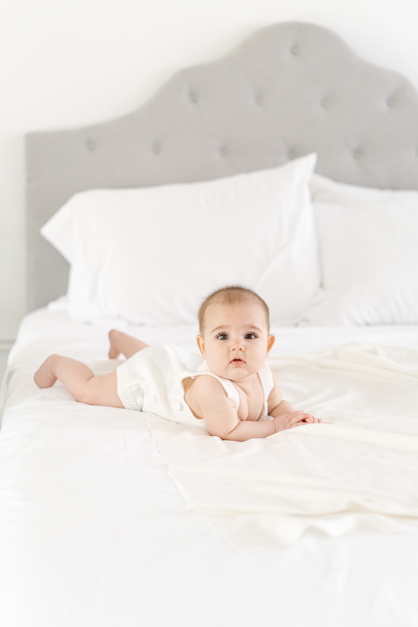 Baby doing tummy time on bed during 6 month milestone session in Asheville, NC. Photo by Lauren Sosler Photography.
