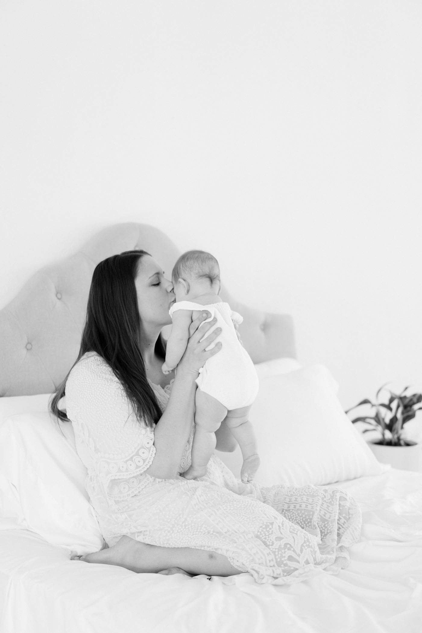 Black and white image of mom kissing baby during session in Asheville, NC. Photo by Lauren Sosler Photography.