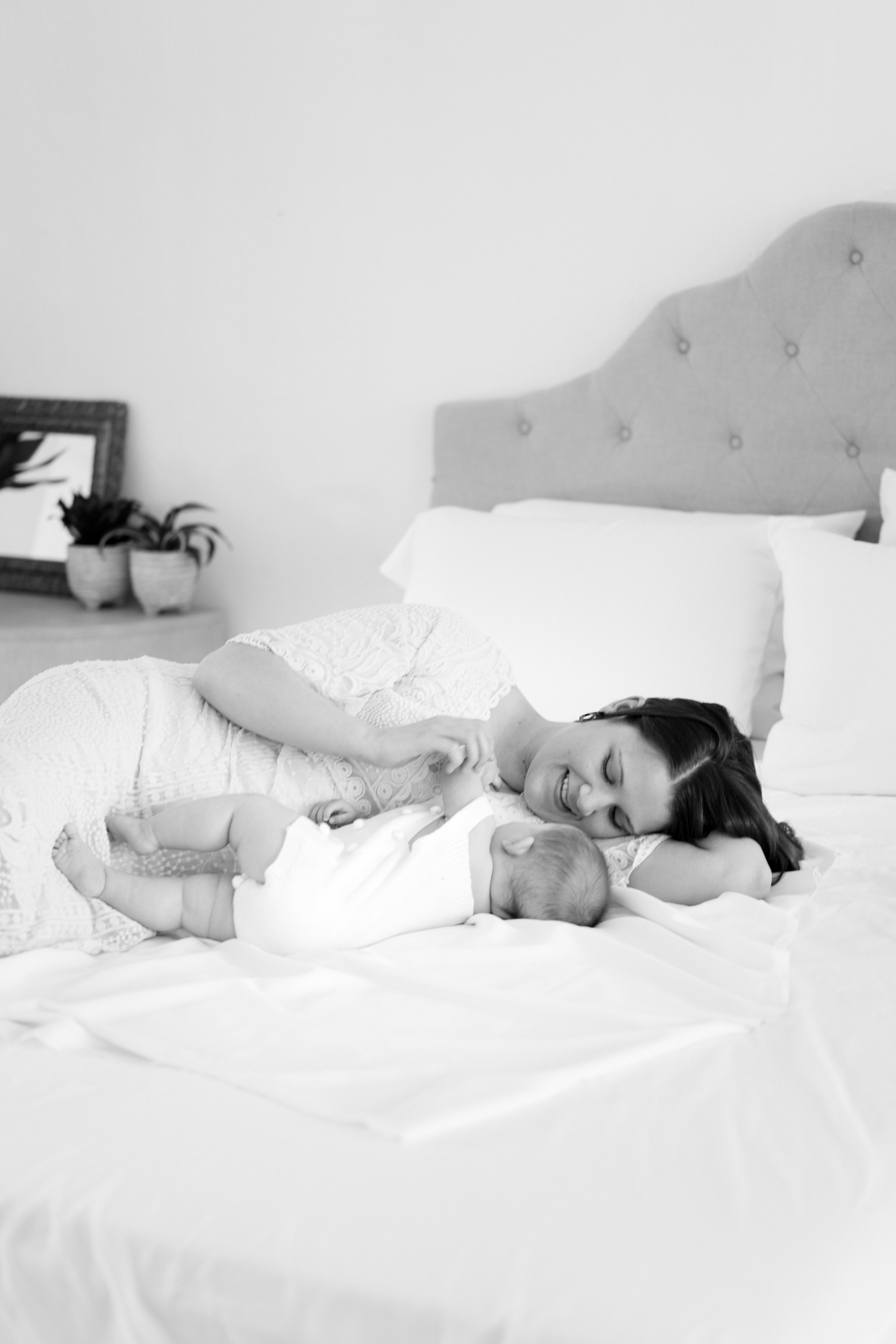 Black and white image of Mom cuddling with baby on bed. Photo by baby photographer in Asheville NC, Lauren Sosler Photography.